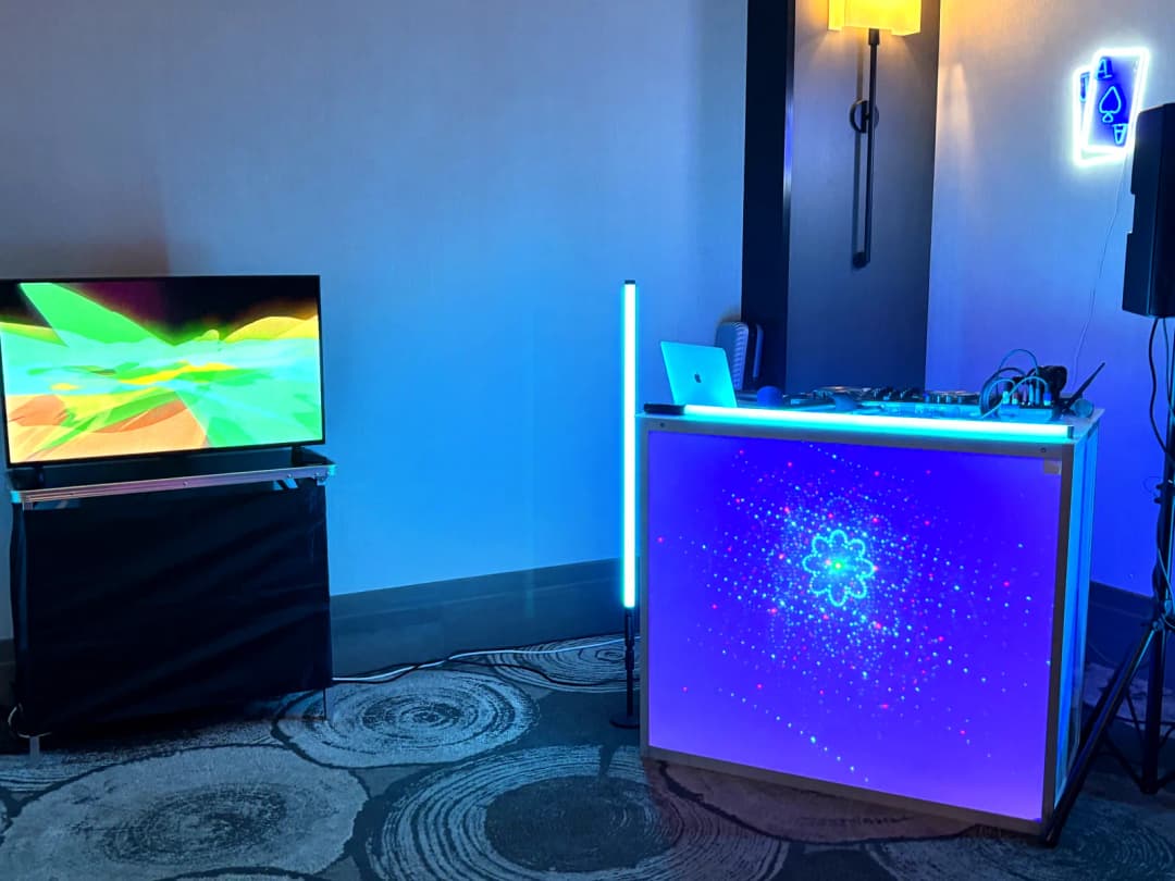 Glowing DJ booth with laser lighting and speakers at an event