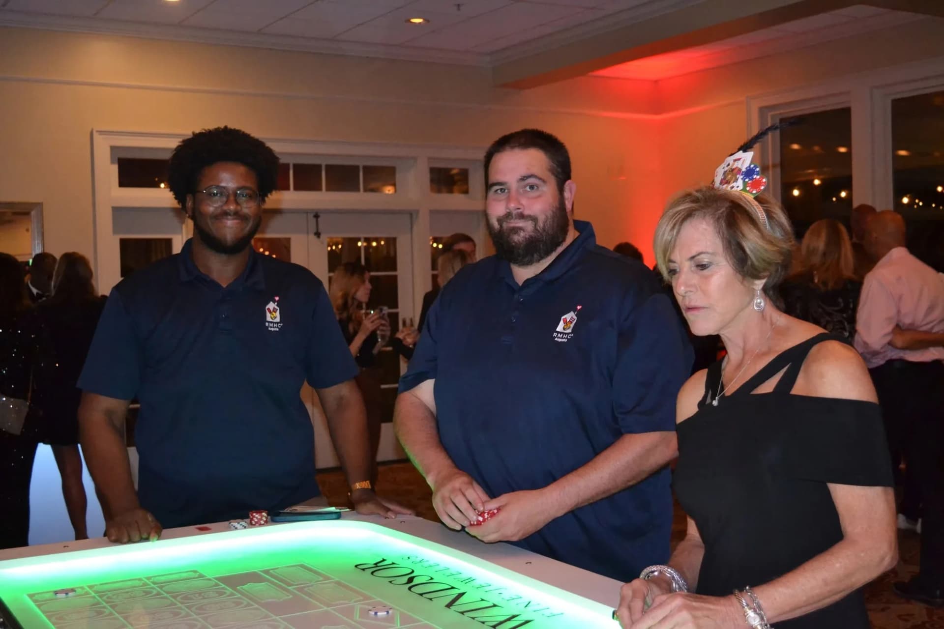 Guests at a sponsored glow craps table at a fundraiser gala