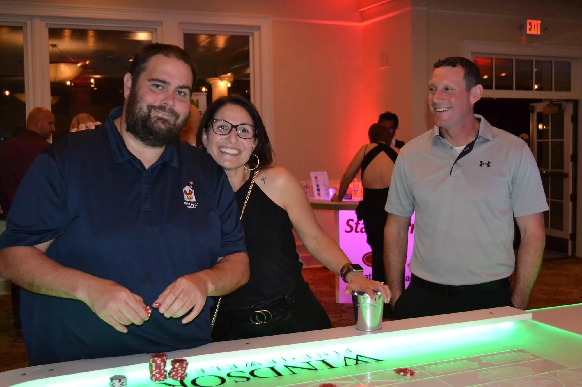 Guests at a sponsored glow table with chips at a casino night fundraiser
