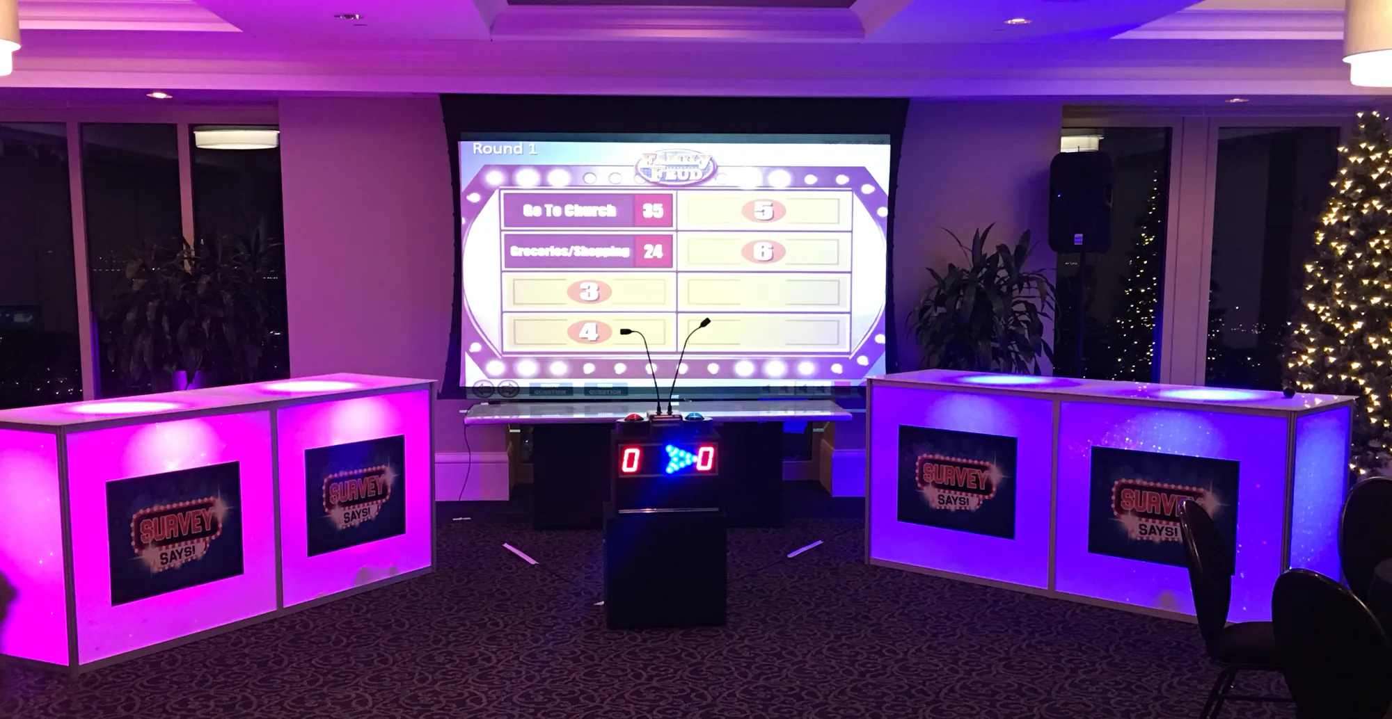 Survey Says game show set with glow podiums and scoreboard at an event venue