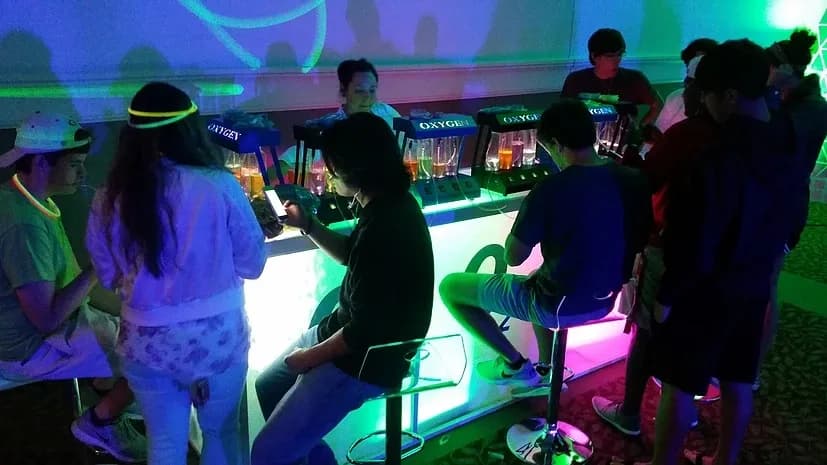 Guests gathered around a glowing oxygen bar using it at an event