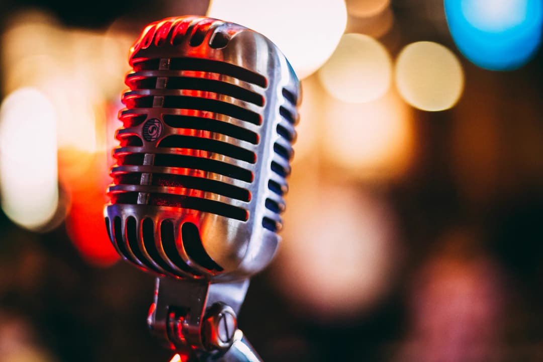 Studio microphone and acoustic guitar prepared for songwriting