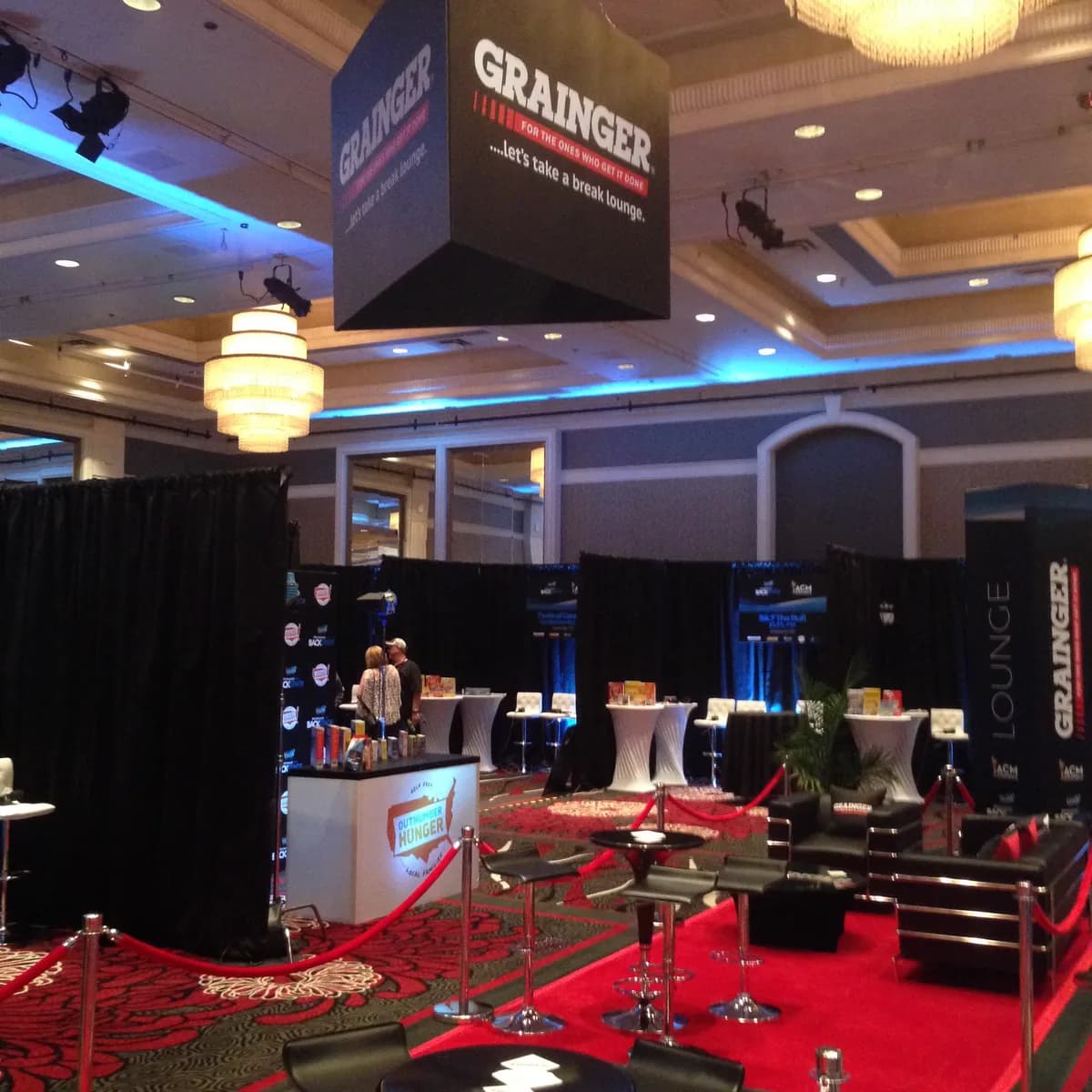 Guests gathered around an interactive event activation with hosts and themed lighting