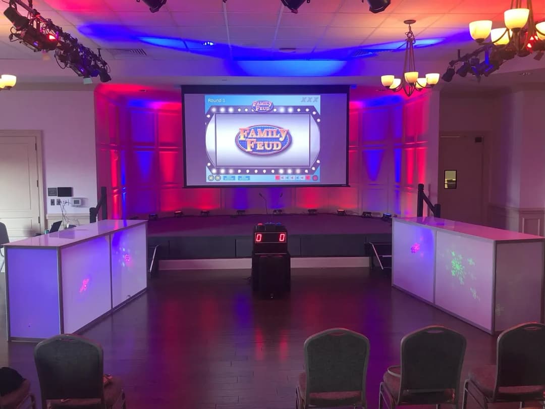 Glow game show set with podiums and big screen lit purple