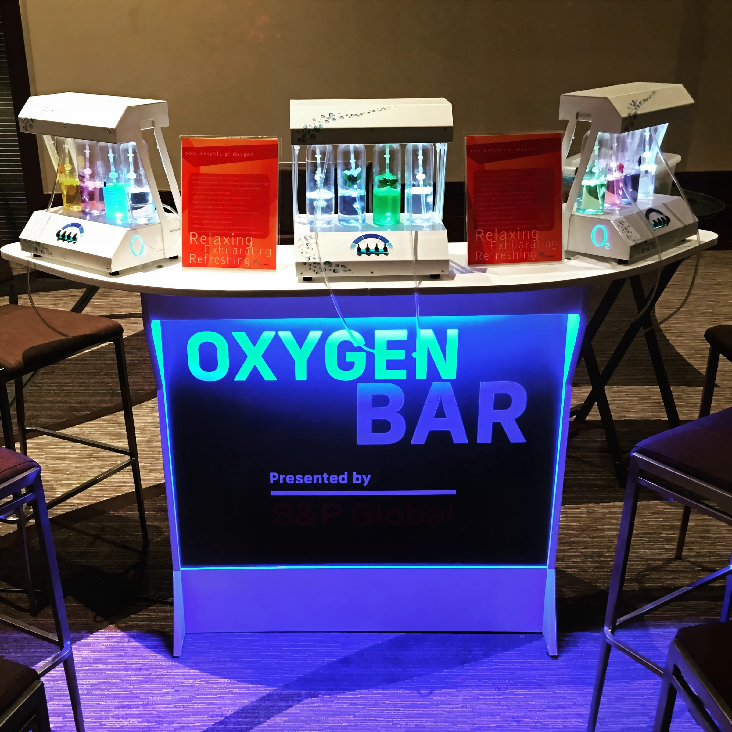 Guests gathered around a branded interactive event activation at an evening corporate function